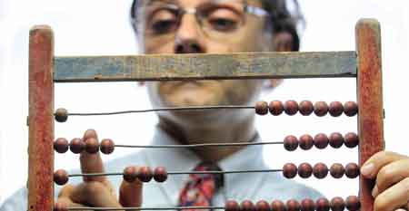 A man calculates numbers on an abacus