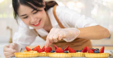 A Cottage Food baker puts the finishing touches to an order of strawberry tarts