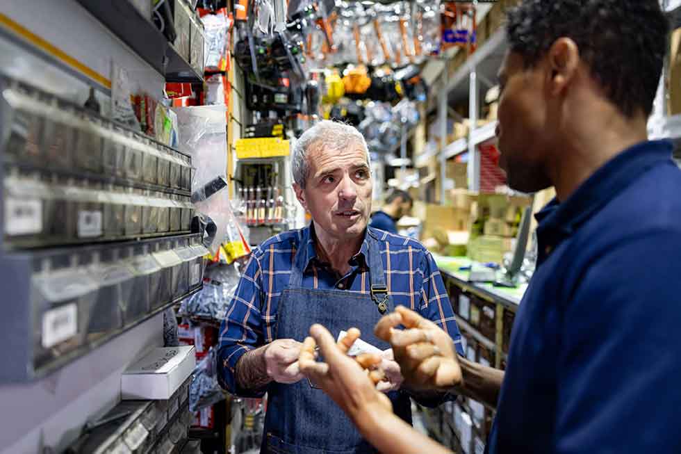 A hardware store owner explains how to use a product to a customer
